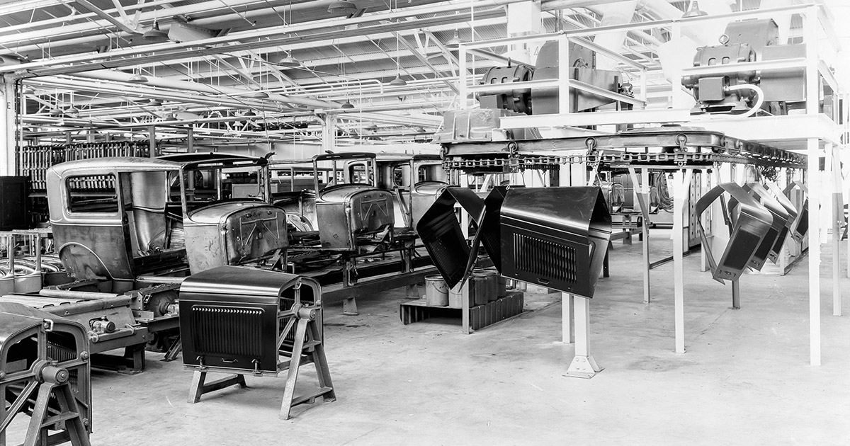 Old Ford factory with parts and sections of old vehicles all around.